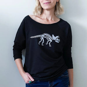 This 3/4 sleeve black raglan shirt displays the skeleton of a triceratops, printed in silver ink. 