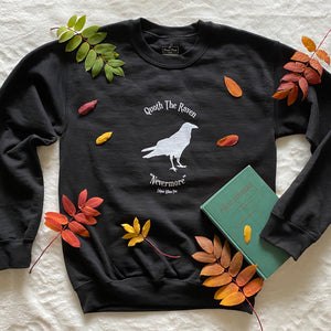 This black crewneck sweater contains a white silhouette of a raven in the centre of the graphic. At the top are the words "Quoth the Raven" and at the bottom "Nevermore." Edgar Allan Poe.
